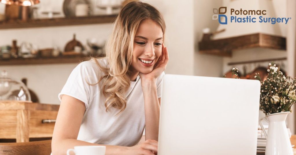 Blond woman working on laptop (MODEL) Potomac Plastic Surgery Logo.